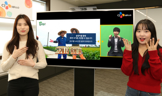 CJ헬로 모델들이 지역채널 오리지널 프로그램 셰프의 팔도밥상 화면 옆에서 '편하다'(왼쪽)와 '새롭다'(오른쪽)를 수어(手語)로 표현하며 스마트 수어방송 서비스를 제공하고 있다.   CJ헬로 제공